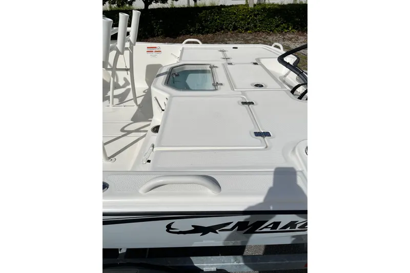 Slide: The Image of 2024 Mako Pro Skiff 19 CC boat deck with storage compartments and rod holders. - 8