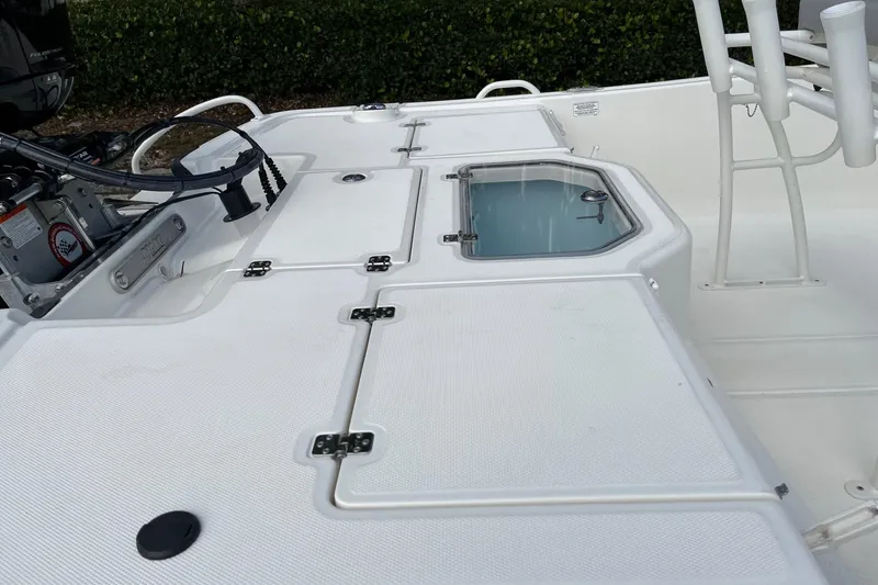Slide: The Image of 2024 Mako Pro Skiff 19 CC boat deck with storage compartments and livewell. - 9