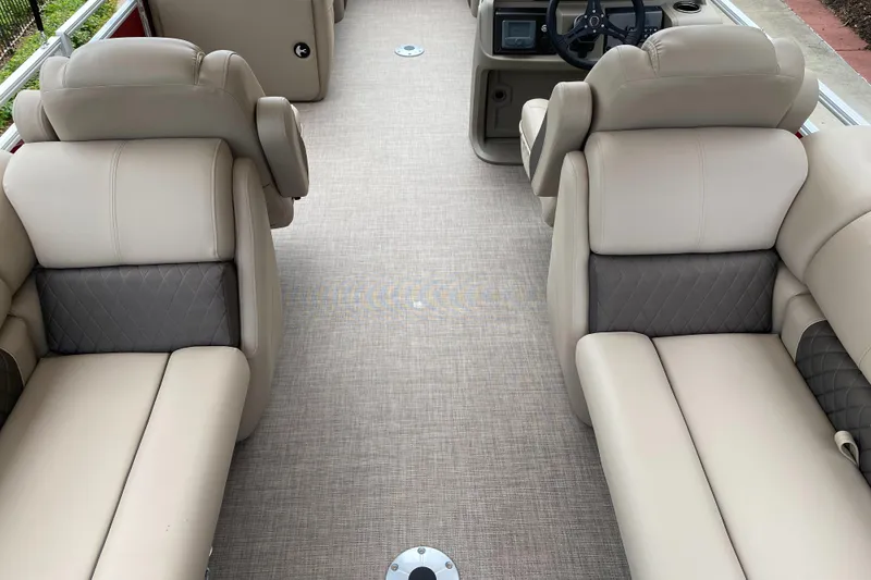 Slide: The Image of 2025 Sun Tracker Party Barge 22 DLX interior with beige seating and steering console. - 5