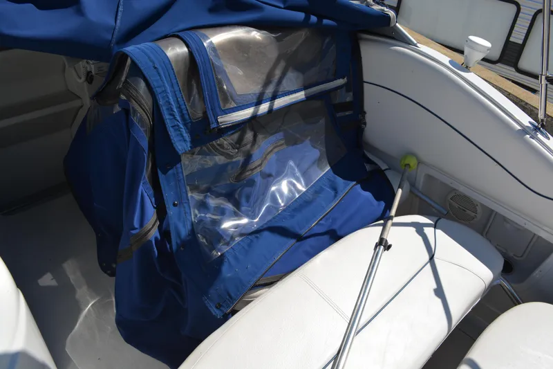 Slide: The Image of 2004 Crownline 270 CR boat interior with blue cover and white seating. - 15