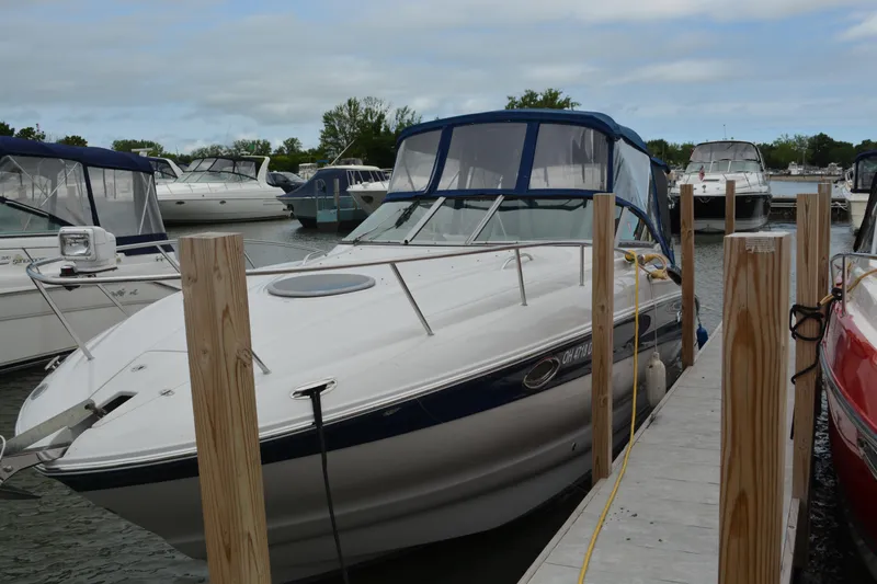 Slide: The Image of 2004 Crownline 270 CR boat docked at marina, surrounded by other vessels. - 2
