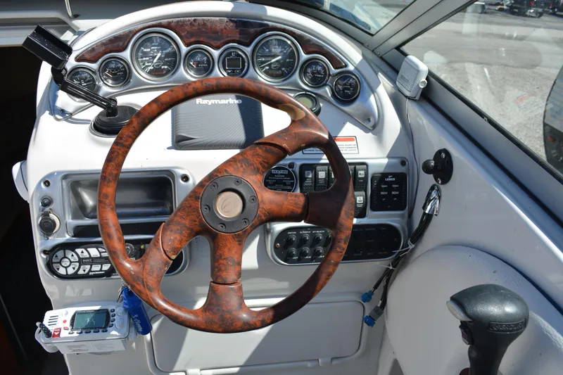 Slide: The Image of 2004 Crownline 270 CR boat dashboard with wood-grain steering wheel and instrument panel. - 21