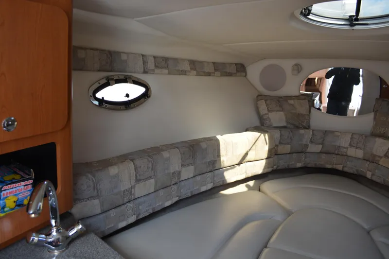 Slide: The Image of Interior of 2004 Crownline 270 CR boat with cushioned seating and porthole window. - 24