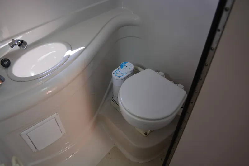 Slide: The Image of Compact bathroom in 2004 Crownline 270 CR boat with sink and toilet. - 29