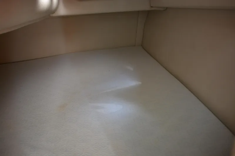 Slide: The Image of Interior cabin space of a 2004 Crownline 270 CR boat, featuring beige upholstery. - 31