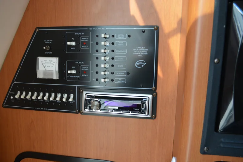 Slide: The Image of Control panel of a 2004 Crownline 270 CR boat, featuring switches and a stereo system. - 32