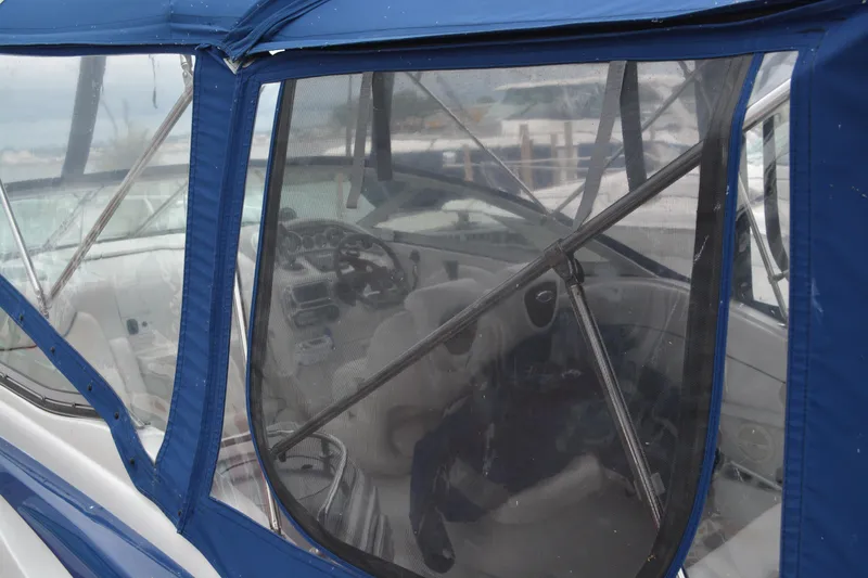 Slide: The Image of 2004 Crownline 270 CR boat interior with blue canopy and visible steering wheel. - 5