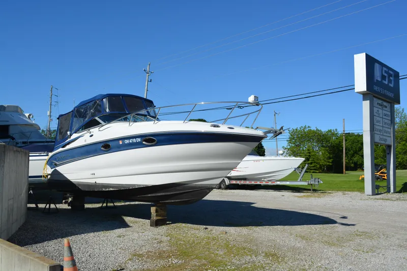 Slide: The Image of 2004 Crownline 270 CR boat on display at a dealership, clear blue sky background. - 6