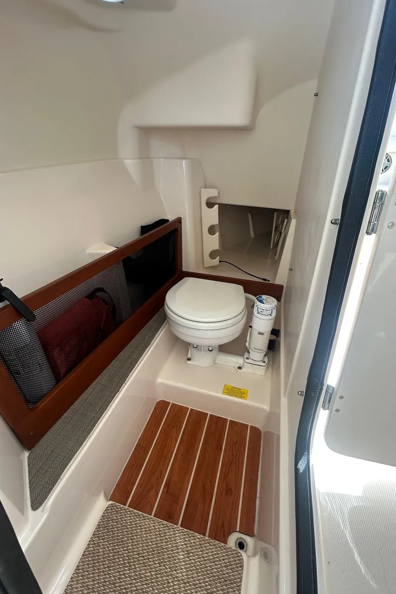 Slide: The Image of 2017 Grady-White Freedom 275 boat interior with toilet and wooden flooring. - 11