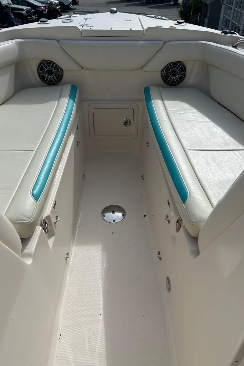 Slide: The Image of 2017 Grady-White Freedom 275 boat interior with white seating and teal accents. - 12