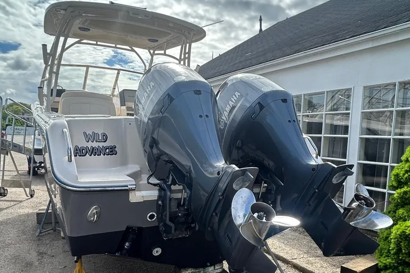 Slide: The Image of 2017 Grady-White Freedom 275 boat with dual Yamaha engines, docked near a building. - 2