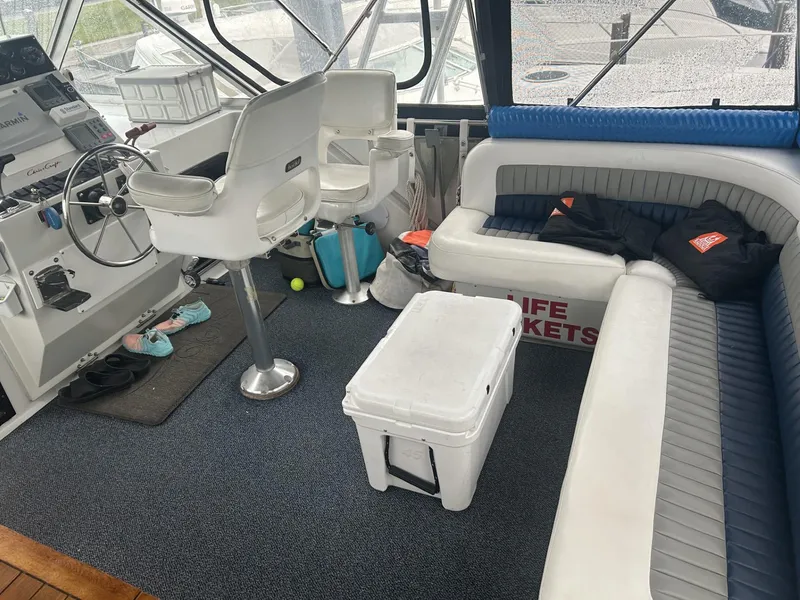 Slide: The Image of 1988 Chris-Craft 381 Catalina interior with helm, seating, cooler, and life jackets. - 13