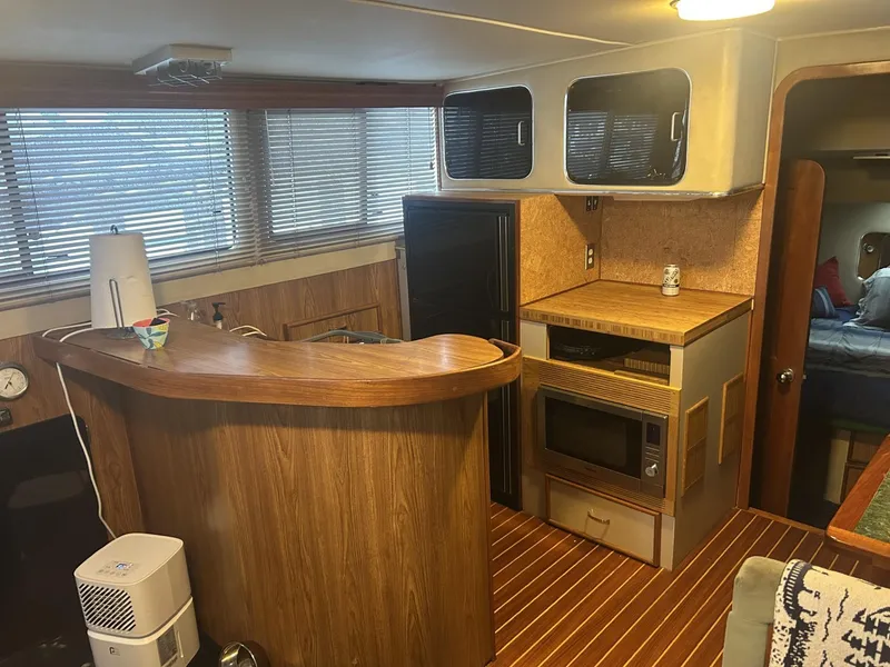 Slide: The Image of Interior of 1988 Chris-Craft 381 Catalina yacht with wood paneling and kitchenette. - 18