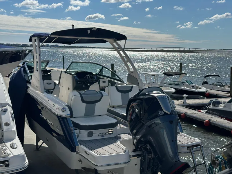 Slide: The Image of 2023 Chaparral 250 OSX boat docked at marina, sunny day, calm waters. - 11