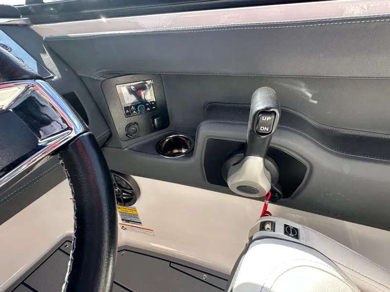 Slide: The Image of 2023 Chaparral 250 OSX boat interior with control panel and cup holder. - 23