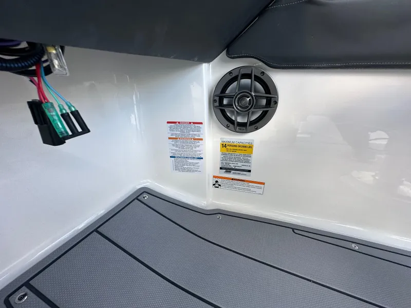 Slide: The Image of 2023 Chaparral 250 OSX boat cockpit with dual displays and steering wheel, docked by the water. - 28