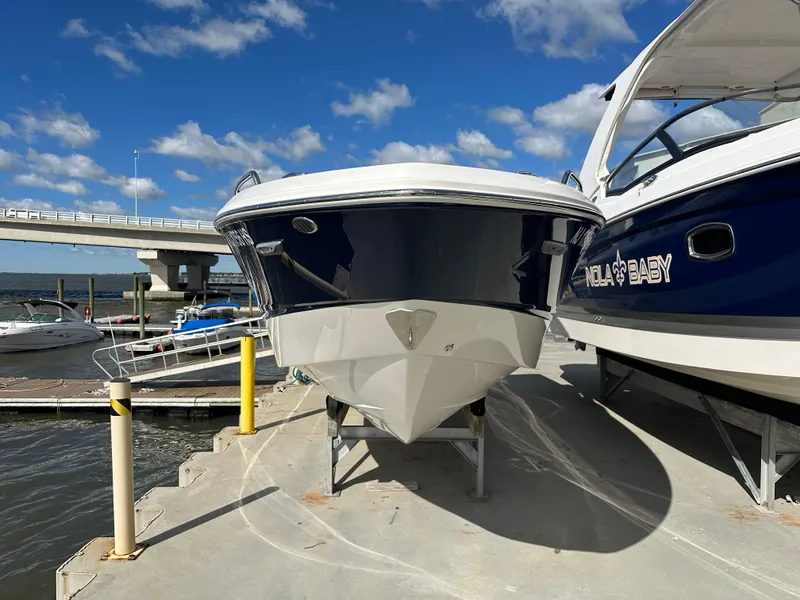 Slide: The Image of 2023 Chaparral 250 OSX boat docked under a clear blue sky. - 3
