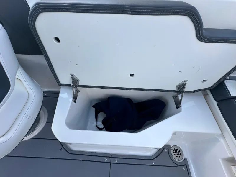 Slide: The Image of 2023 Chaparral 250 OSX boat interior with steering wheel and seating, overlooking a scenic waterfront. - 30