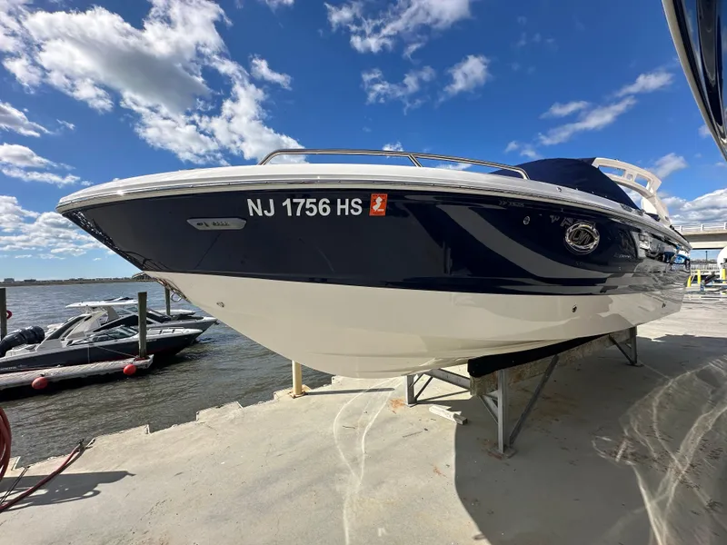 Slide: The Image of 2023 Chaparral 250 OSX boat docked under a clear blue sky. - 4