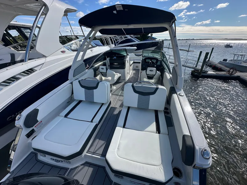 Slide: The Image of 2023 Chaparral 250 OSX boat with sleek design, spacious seating, and waterfront view. - 40