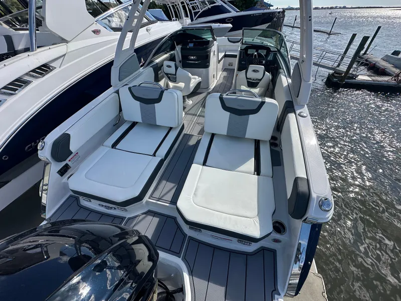 Slide: The Image of 2023 Chaparral 250 OSX boat with luxurious seating on a sunny waterfront. - 41