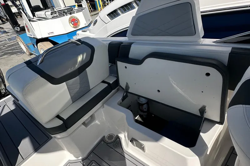 Slide: The Image of 2023 Chaparral 250 OSX boat interior with open storage compartment and seating. - 44