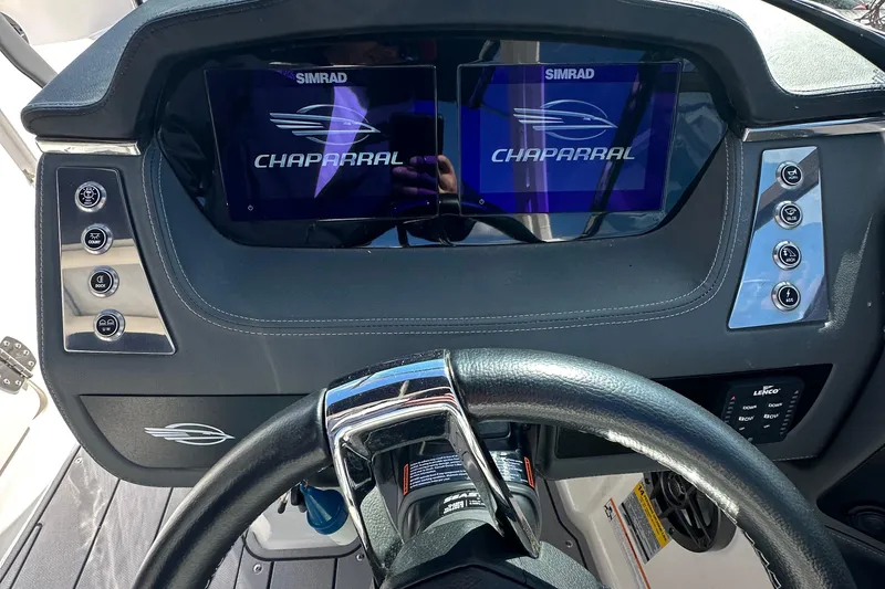 Slide: The Image of 2023 Chaparral 250 OSX boat dashboard with dual Simrad displays and steering wheel. - 48