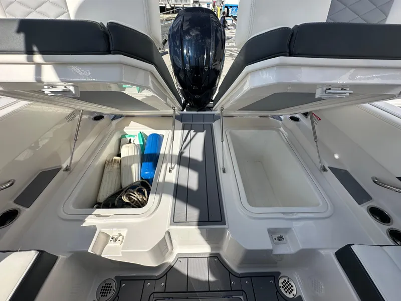 Slide: The Image of 2023 Chaparral 250 OSX boat storage compartments with open lids and visible equipment. - 8