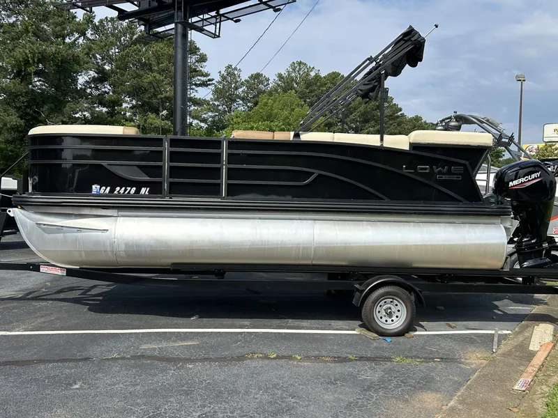 Slide: The Image of 2022 Lowe 190 SS pontoon boat on trailer, black exterior, parked outdoors. - 0