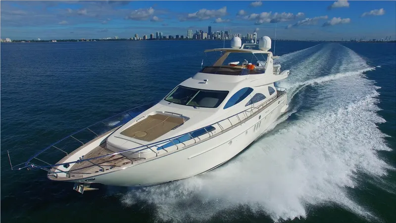 Slide: The Image of Azimut 80 Carat 2005 yacht cruising on open water with city skyline in background. - 14