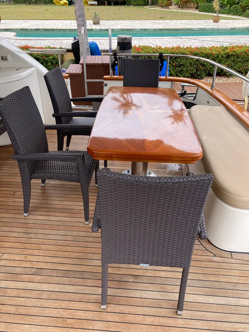 Slide: The Image of Outdoor dining area on 2005 Azimut 80 Carat yacht with wooden table and wicker chairs. - 20