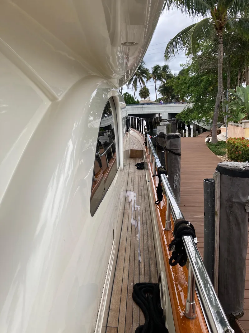 Slide: The Image of 2005 Azimut 80 Carat yacht with sleek design and wooden deck, docked near palm trees. - 32