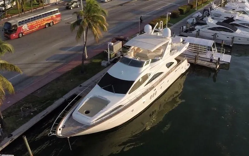 Slide: The Image of Luxury 2005 Azimut 80 Carat yacht docked near palm-lined street. - 10