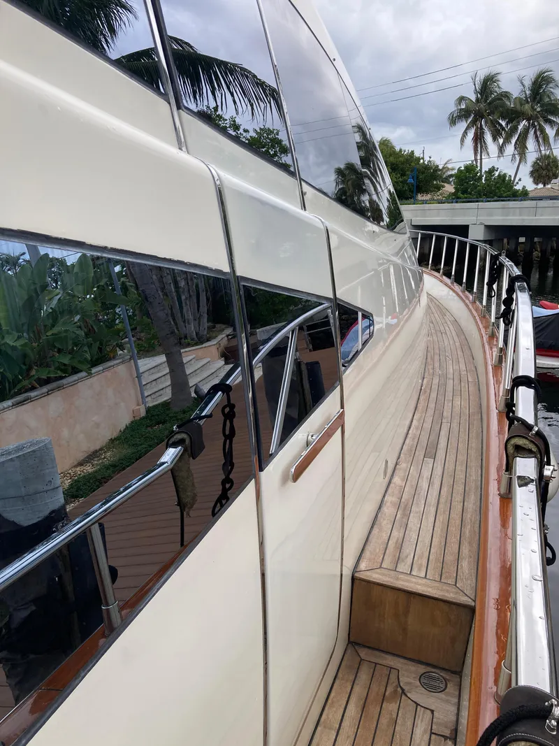 Slide: The Image of 2005 Azimut 80 Carat yacht with sleek design and wooden deck, docked near palm trees. - 31