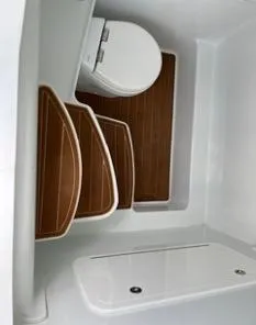 Slide: The Image of 2022 Yellowfin 39 Offshore boat interior with wooden flooring and compact toilet. - 16