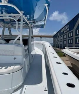 Slide: The Image of 2022 Yellowfin 39 Offshore boat docked near a marina under a clear blue sky. - 28