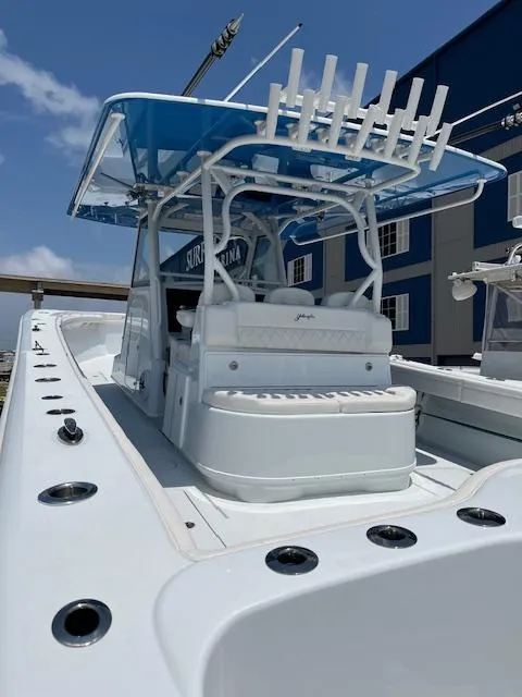Slide: The Image of 2022 Yellowfin 39 Offshore boat with blue canopy and rod holders, docked under clear sky. - 4