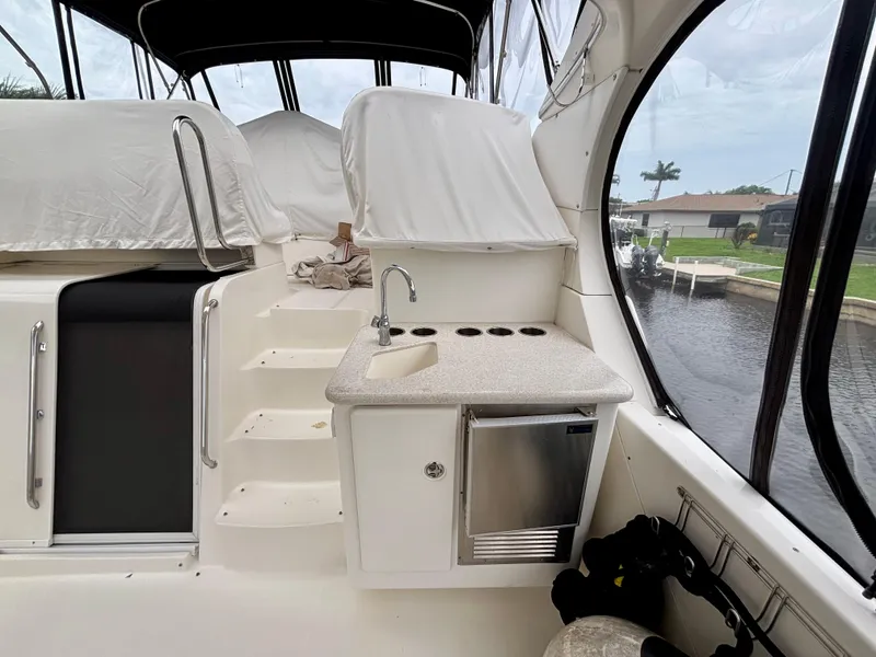 Slide: The Image of 2005 Silverton 39 Motor Yacht interior with kitchenette and steps, dockside view. - 11