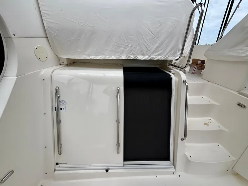 Slide: The Image of 2005 Silverton 39 Motor Yacht, rear deck with covered seating and steps. - 16