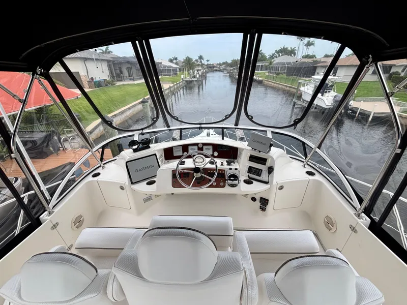 Slide: The Image of 2005 Silverton 39 Motor Yacht helm with canal view, featuring modern navigation equipment. - 17