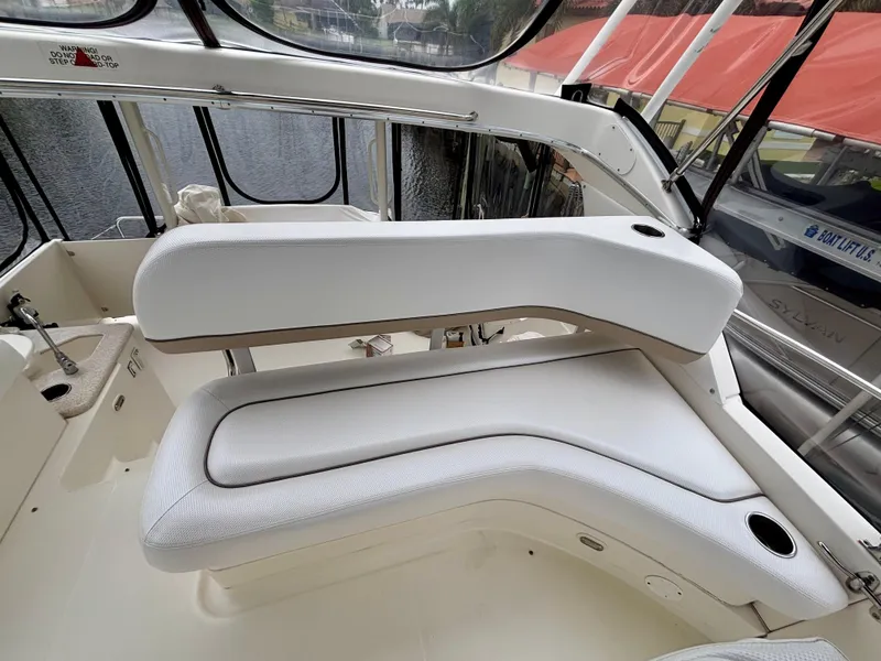 Slide: The Image of 2005 Silverton 39 Motor Yacht interior seating with white cushions and cup holders. - 20