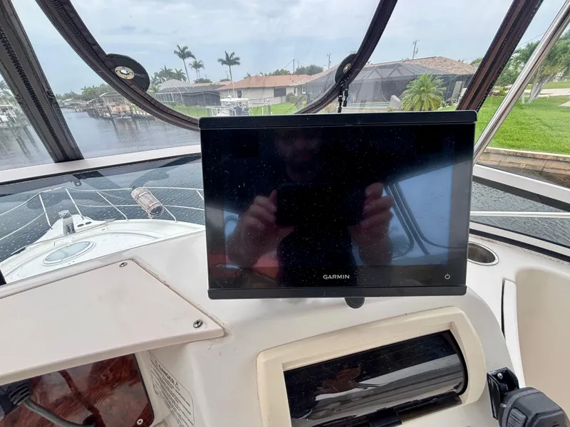Slide: The Image of 2005 Silverton 39 Motor Yacht helm with Garmin display, overlooking a serene waterfront view. - 33