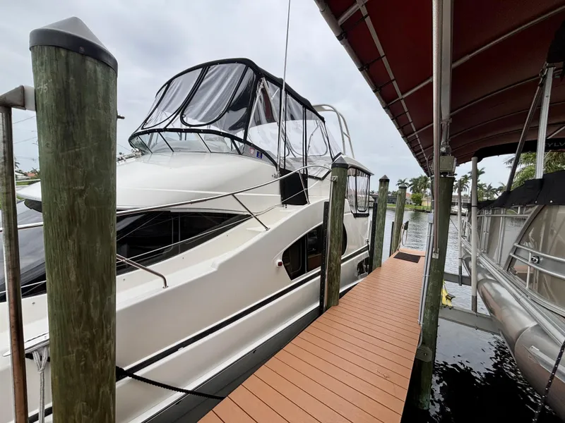 Slide: The Image of 2005 Silverton 39 Motor Yacht docked beside a wooden pier under a canopy. - 4
