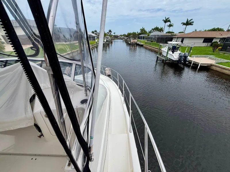 Slide: The Image of 2005 Silverton 39 Motor Yacht docked in a scenic canal with palm trees. - 45