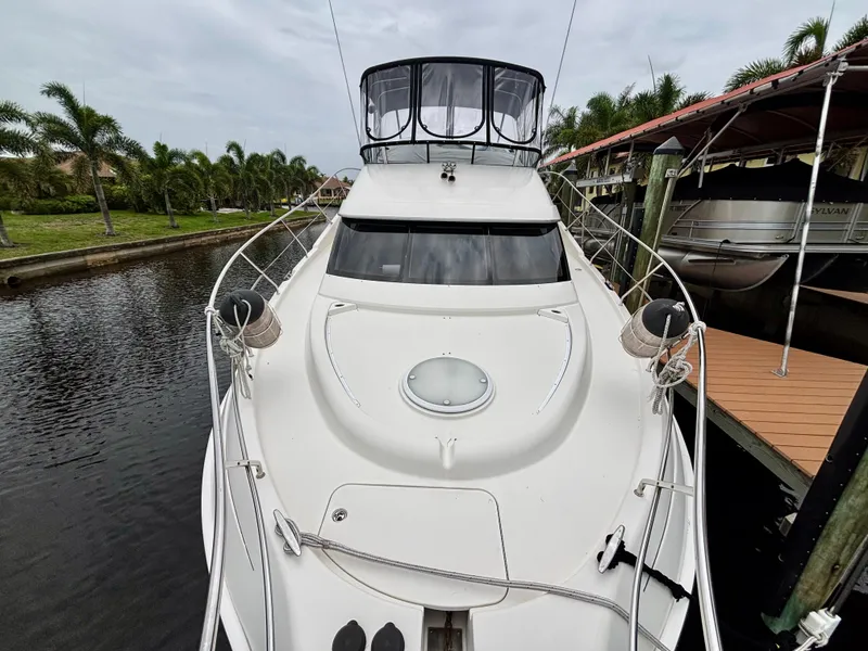 Slide: The Image of 2005 Silverton 39 Motor Yacht docked near palm trees, front view. - 47