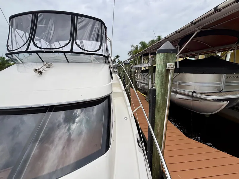 Slide: The Image of 2005 Silverton 39 Motor Yacht docked beside wooden pier under cloudy sky. - 49