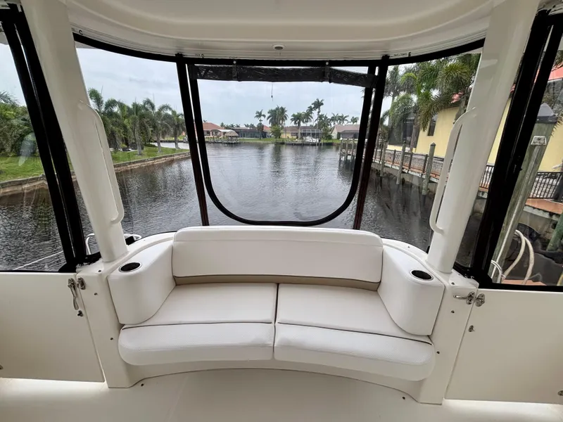 Slide: The Image of 2005 Silverton 39 Motor Yacht interior with white seating, overlooking a serene waterfront view. - 8