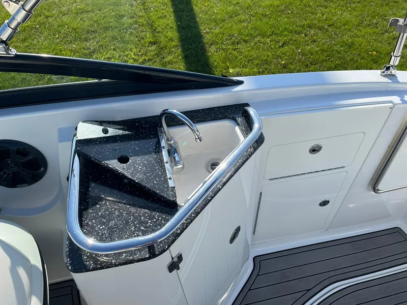 Slide: The Image of Monterey M4 2015 boat sink area with black countertop and storage compartments. - 31