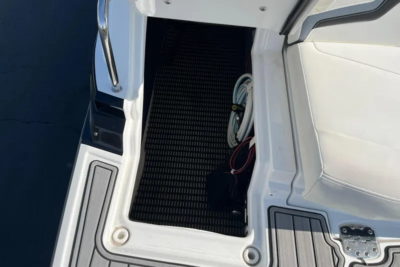 Slide: The Image of 2015 Monterey M4 boat interior with white seating and storage compartment. - 34
