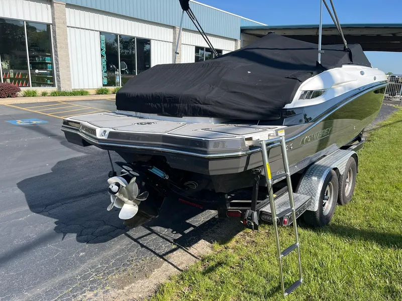 Slide: The Image of 2015 Monterey M4 boat on trailer, covered, parked outdoors near a building. - 6